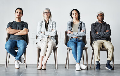 Buy stock photo Businesspeople waiting in line for an interview. Patients sitting in line at doctor's office. Therapist sitting with patients in a row. Portrait of diverse businesspeople with arms crossed.  