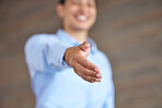 Closeup of a businesswoman giving a handshake. Female employee reaching her hand out to shake on a deal in a modern office