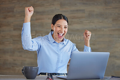 Young happy and excited mixed race businesswoman cheering with her fists working on a laptop sitting in an office at work. Hispanic businessperson celebrating success. Woman smiling after a victory