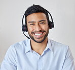 Portrait of a young mixed race call center agent working in his office. Operator at his reception job. Hispanic man wearing a wireless headset smiling while directing calls in customer service