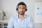 Portrait of a young mixed race businessman working in a call center. Operator at his office job. Hispanic man working, wearing a headset and working in customer service, on a call. 