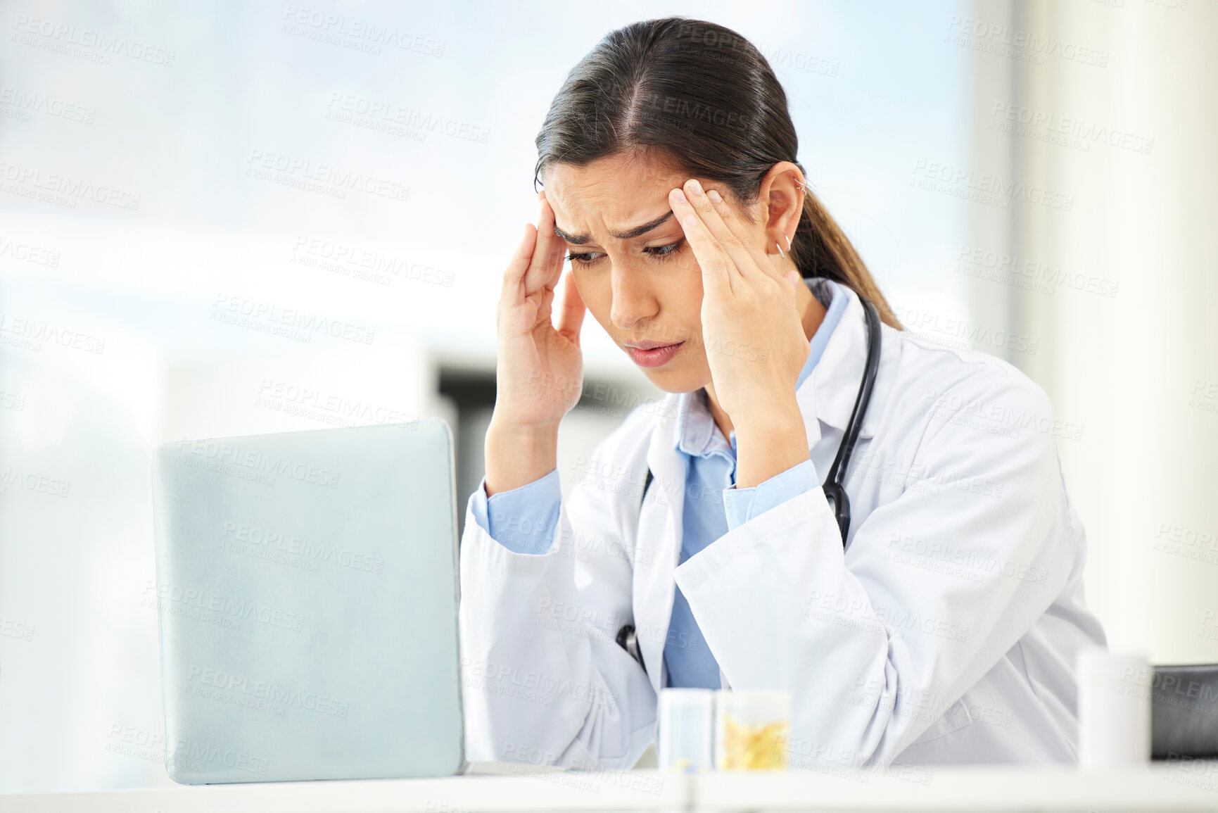 Buy stock photo Mental health, woman doctor with headache and laptop at her desk in a modern office. Anxiety or stress, depression or mistake and sad female surgeon or nurse at her workstation with problem at work