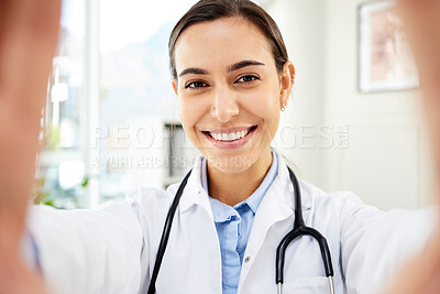 Buy stock photo Portrait of a young mixed race female doctor taking a selfie while smiling and wearing a stethoscope in a hospital office