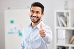Young happy handsome mixed race businessman showing a thumbs up standing in an office alone at work. One pleased hispanic male boss smiling holding up a thumb in agreement