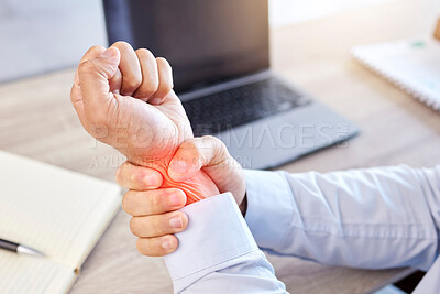 Closeup of hand and wrist pain highlighted in red. A businessman holding his arm with an injury. Male employee working at his desk in a modern office and suffering from a medical problem