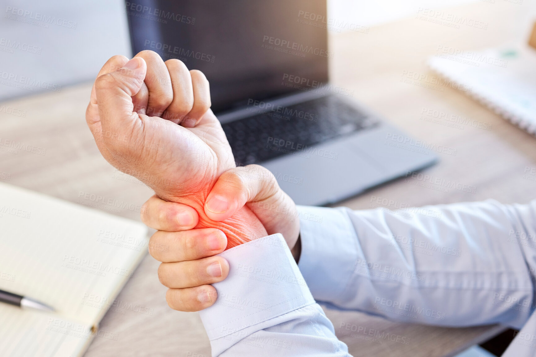 Buy stock photo Closeup of hand and wrist pain highlighted in red. A businessman holding his arm with an injury. Male employee working at his desk in a modern office and suffering from a medical problem