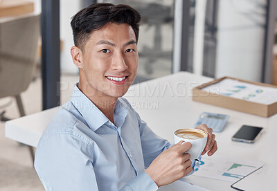 Asian businessman enjoying a cup of coffee. Young businessman taking a break to drink coffee. Portrait of happy businessman relaxing at work. Business professional drinking a cappuccino