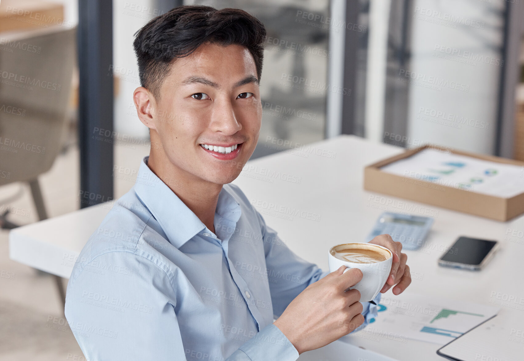 Buy stock photo Asian businessman enjoying a cup of coffee. Young businessman taking a break to drink coffee. Portrait of happy businessman relaxing at work. Business professional drinking a cappuccino 