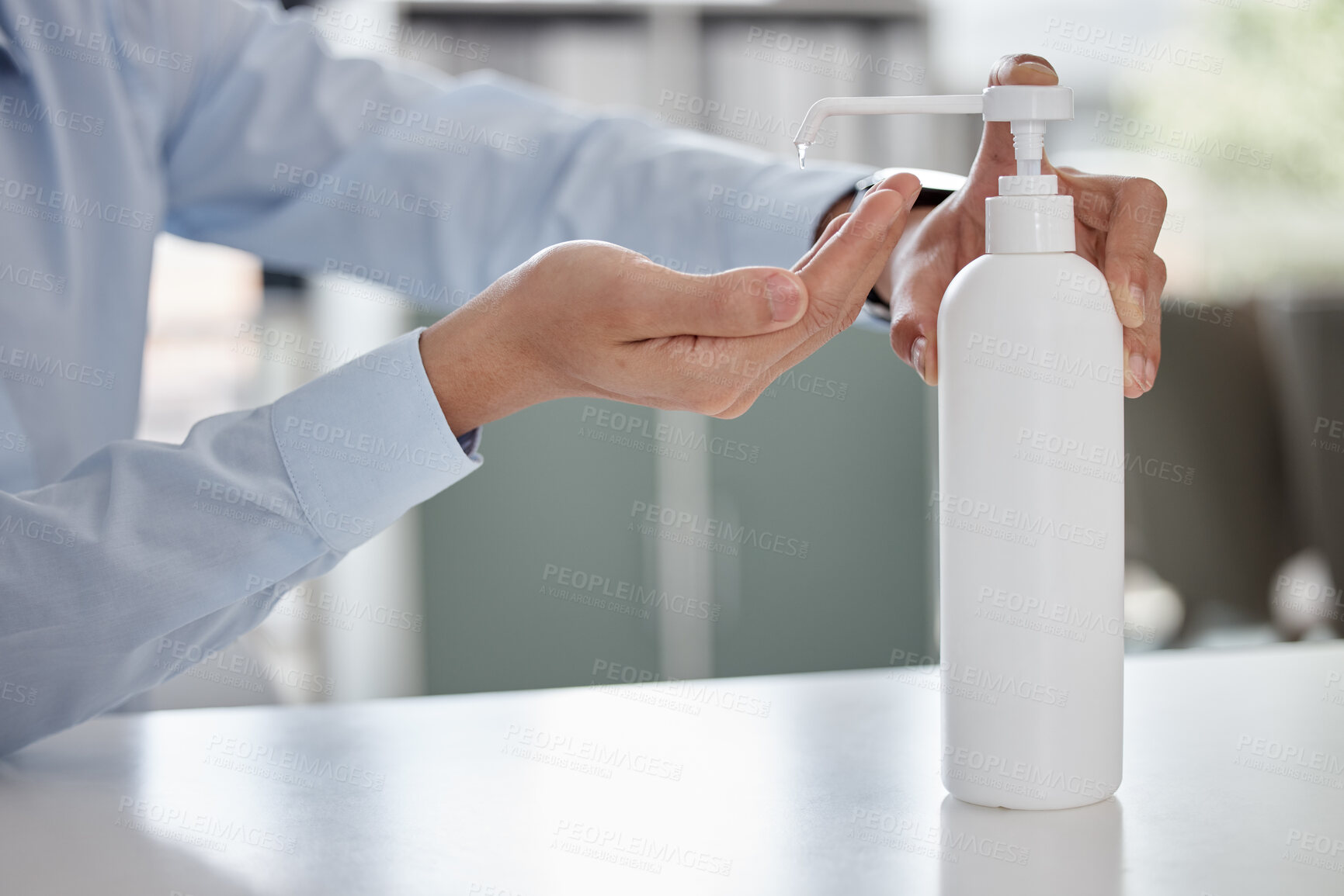 Buy stock photo Closeup of male hands using sanitiser at workplace. Bottle of alcohol gel placed on desk in office to clean hands and kill or prevent spread of germs during coronavirus outbreak