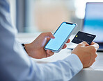 Closeup of one businessman spending money online with a credit card and phone in an office. Making purchase transaction with secure banking payment. Budgeting finance for bills and e-commerce shopping