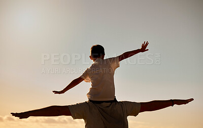 Buy stock photo Silhouette of father carrying son on his shoulders at sunset. Rear view of unknown man and child pretending they can fly with their arms outstretched. Single parent bonding with his little boy outside