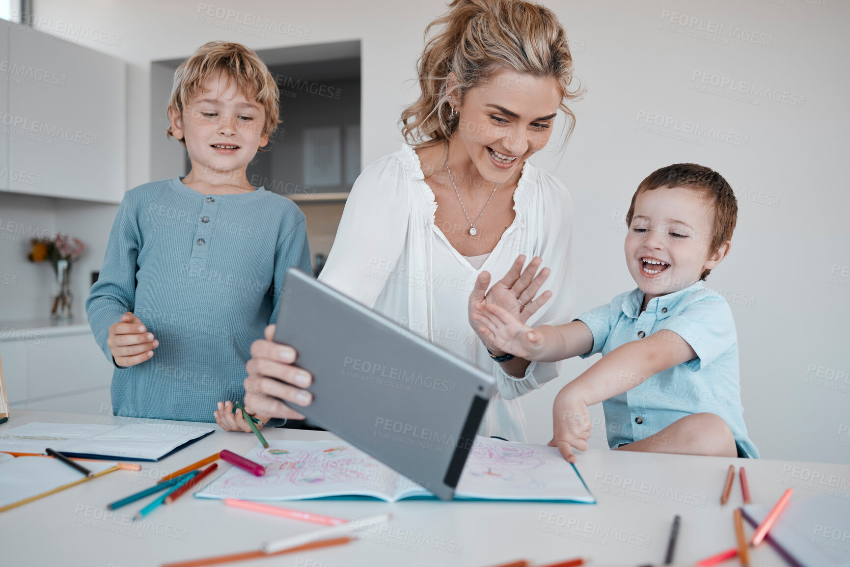 Buy stock photo Family on a distance learning video call, learning or teaching online. A happy mother and her little boy using a digital tablet for an online education. Parent helping with homework