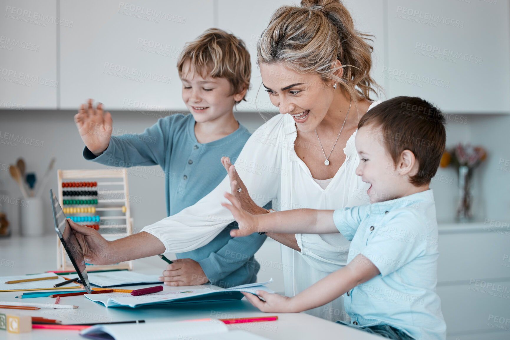 Buy stock photo Family on a distance learning video call, learning or teaching online. A happy mother and her little boy using a digital tablet for an online education. Parent helping with homework
