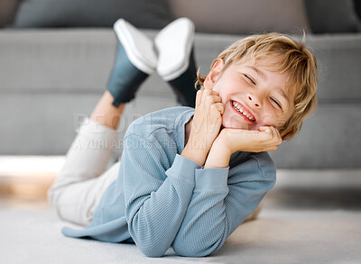Buy stock photo Portrait of a happy boy child looking and smiling at the camera with dental teeth showing. Adorable caucasian kid lying on the floor and relaxing at home. For a healthy mouth and gums, start young