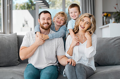 Buy stock photo Portrait of smiling caucasian family relaxing together on a sofa at home. Carefree playful little sons hugging arms around loving parents. Happy kids bonding and spending quality time with mom and dad