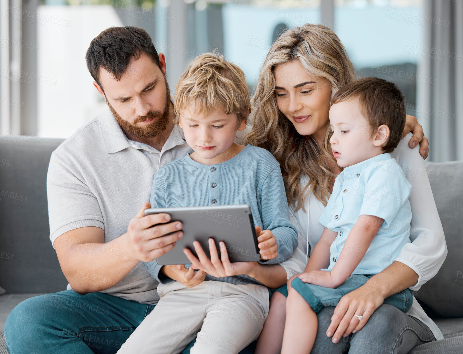 Buy stock photo Loving family with two kids sitting at home with device. Caucasian parents and little children using digital tablet looking at screen sitting on sofa together. Family watching cartoon movie online