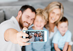 Closeup of cellphone screen showing happy caucasian family taking selfies at home. Loving parents capturing photos and pictures for special childhood memories while bonding with carefree smiling sons