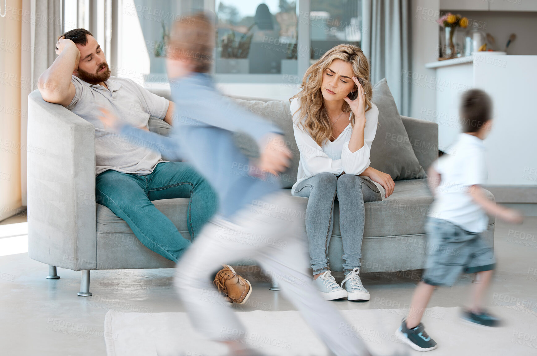 Buy stock photo Headache, parents and children by sofa with adhd, running and impulsive behavior with motion blur at home. Family, mother and father on couch for annoyed, stress and hyper active of kids in house