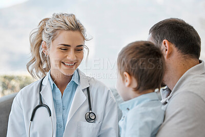Smiling child doctor after a checkup. Happy caucasian healthcare professional with a young little patient and his father after a consult. Single father and son visiting the clinic after getting sick