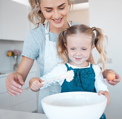 Buy stock photo Mother and daughter baking at home. Happy mother and child bonding and cooking. Woman helping her daughter make batter. Young mother holding an egg, baking with her little girl.
