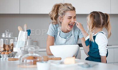 Buy stock photo Playful mother baking with her daughter. Little girl putting flour on her mothers nose. Cheerful mother and daughter baking in the kitchen. Happy parent playing and cooking with her daughter