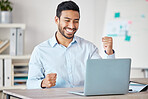 Young happy and excited mixed race businessman cheering with his fist while working on a laptop alone in an office at work. One hispanic male boss smiling while celebrating success