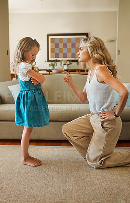 Buy stock photo Young upset caucasian mother scolding her naughty little daughter at home. Sad girl sulking while being disciplined by her mom for being naughty in the lounge