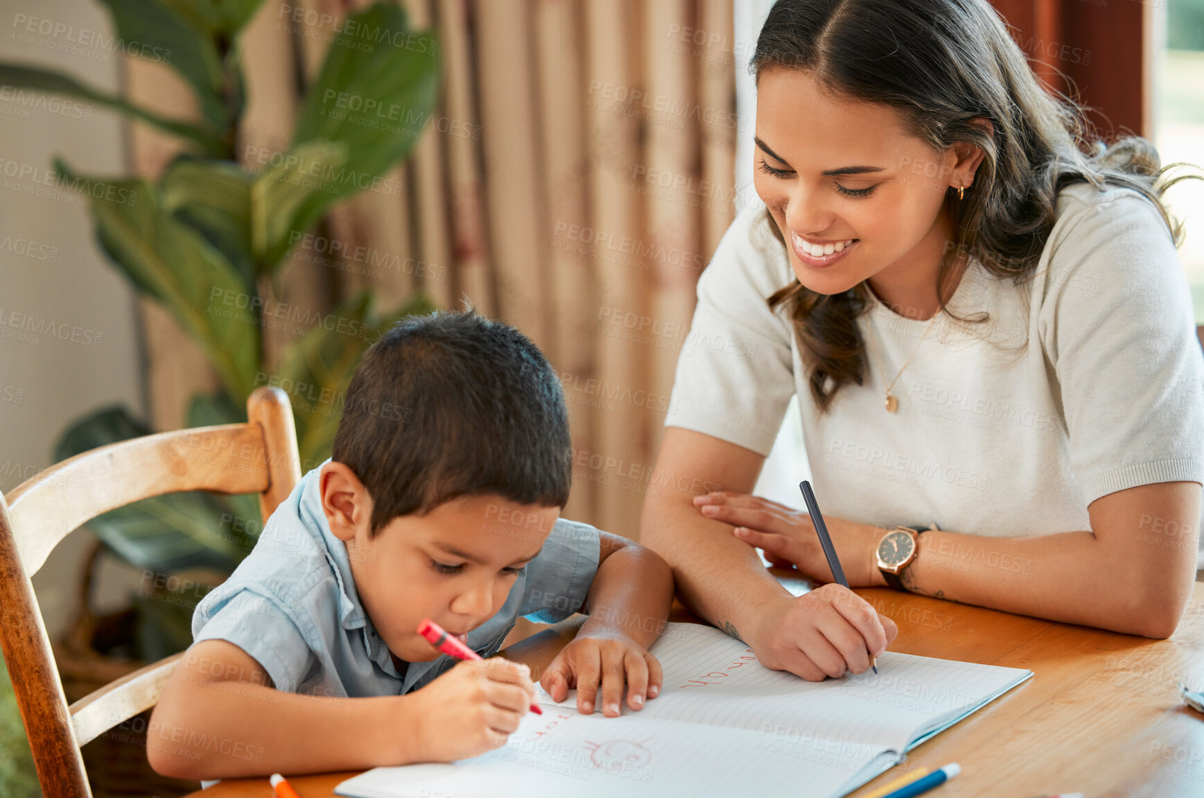 Buy stock photo Mixed race boy learning and studying in homeschool with mom. Woman helping son with homework and assignments at home. Loving parent teaching child to draw, read and write at home in lockdown
