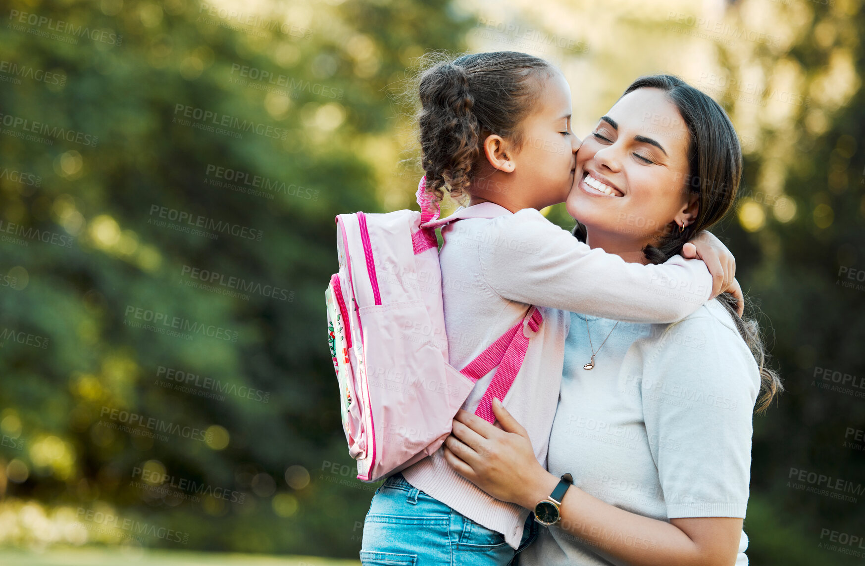 Buy stock photo Little girl kissing her mother. Young mother hugging her daughter. Loving mother hugging daughter before school outside. Little girl going to school. Happy woman embracing daughter