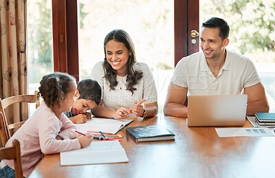 Buy stock photo Young happy mixed race family sitting at a table together at home. Hispanic father working on a laptop while his children draw. Caring mother helping her little son and daughter with homework 