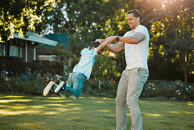 Buy stock photo Happy single father spinning his son outside in a garden. Smiling mixed race man and child playing games and swinging in the backyard. Single parent bonding with his little boy and lifting him midair