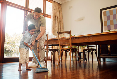 Buy stock photo Mixed race father helping little boy sweep dust and dirt on wooden floor with broom for household chores at home. Cute boy helping dad with daily spring cleaning tasks. Kid learning to be responsible