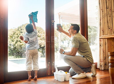 Buy stock photo Little boy helping his father wash and wipe clean glass doors for household chores at home. Happy father and son doing spring cleaning together. Kid learning to be responsible by doing tasks