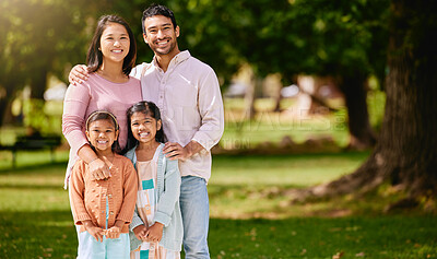 Buy stock photo Portrait of happy asian family relaxing and sharing quality time on a sunny day in nature in a park or garden with copyspace. Loving parents bonding and having fun with carefree smiling daughters