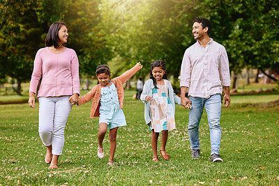 Buy stock photo Park, walk and happy family holding hands, talking and bonding with love, smile and fun in nature. Children, parents and walking in a forest together on the weekend, cheerful and enjoying holiday