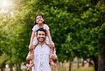 Portrait of happy mixed race father and playful daughter having fun at the park outdoors with copyspace. Carefree man carrying cheerful girl on shoulders for piggyback ride. Parent bonding with kid 