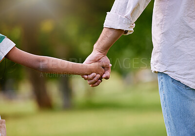Buy stock photo Rearview of a father and daughter holding hands in a park. Mixed race single parent enjoying free time with child outside. Little hispanic girl trusting and bonding with her single father on a weekend