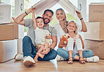 Smiling couple with little kids sitting and mockup roof over children. Cheerful family sitting together on floor in new house on relocation day. Parents and children covered and protected by insurance