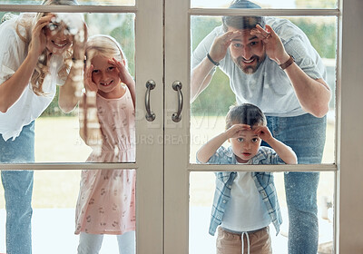 Curious couple with little kids standing and peering into their new home. Excited smiling caucasian family looking at and checking their house from the door. Adorable boy and girl with their parents