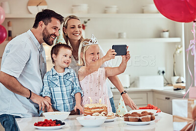 Buy stock photo Happy family celebrating a birthday at home. Parents smiling for selfie or video call with kids while having a party with balloons and cake. Sister celebrating birthday with mother, father and brother