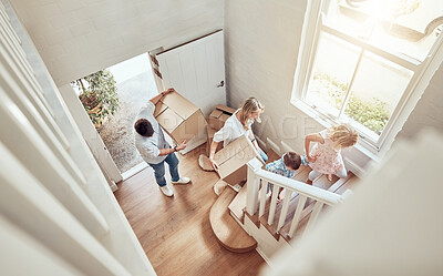 Buy stock photo Above view happy caucasian family moving into their new home and carrying boxes up a staircase. Parents and kids moving in. Mother, father, brother and sister taking their belongings into a new house