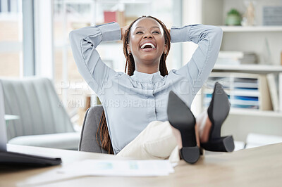 Businesswoman relaxing with her feet on her desk. African american entrepreneur taking a break from work.Cheerful woman resting at work. Happy businesswoman relaxing at her desk after work