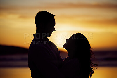 Buy stock photo Silhouette couple enjoying romantic moment standing face to face looking into eyes at sunset. Unknown boyfriend and girlfriend feeling in love while bonding at the beach