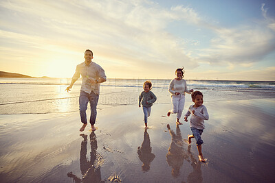 Buy stock photo Portrait of a happy mixed race family of four on vacation by the sea. Children enjoying a getaway with their parents on bright summer day, smiling family relaxed against copyspace background