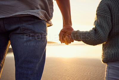 Buy stock photo Father and little girl holding hands while watching the sunset together at the beach. Dad and young daughter showing affection, love and support by holding hands