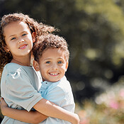 Portrait of a mixed race brother and sister smiling, standing and ...