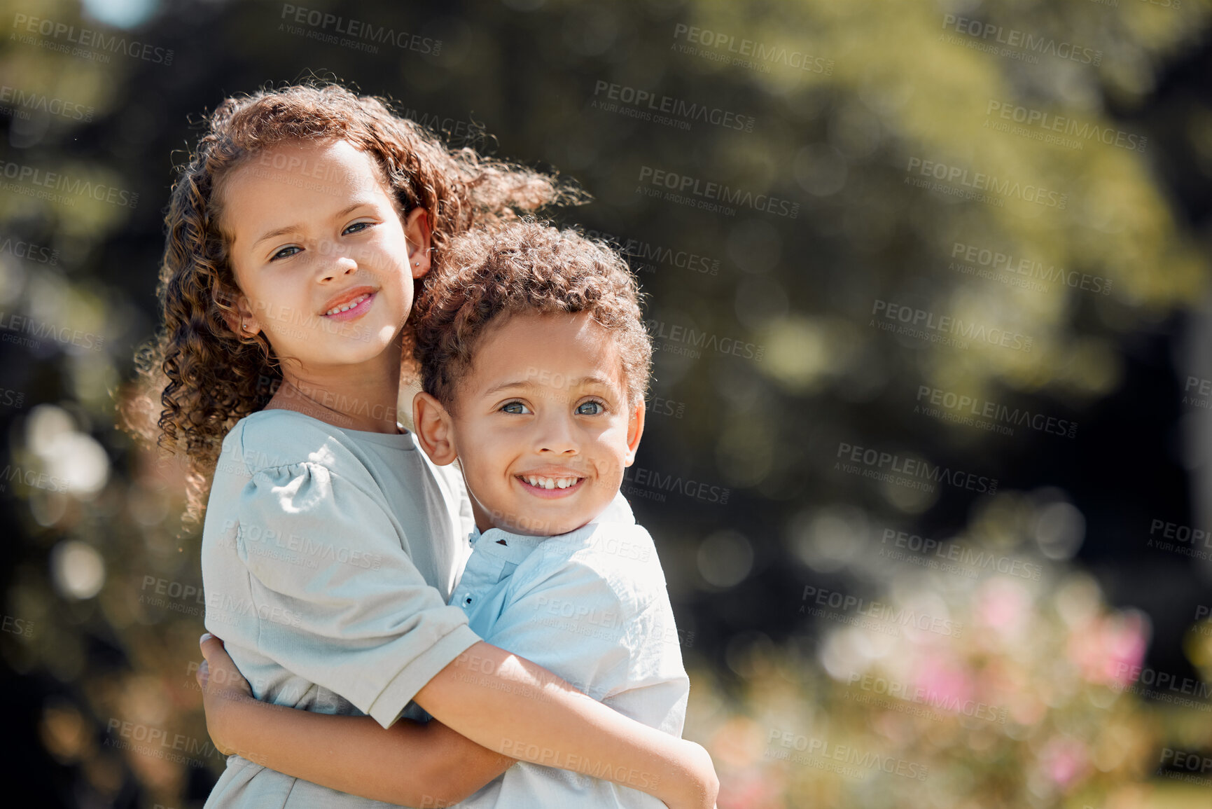 Buy stock photo Portrait of a mixed race brother and sister smiling, standing and embracing each other in a garden outside. Hispanic Male and female siblings showing affection on a sunny day