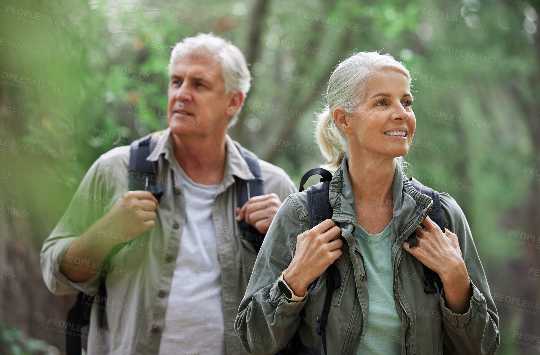 Buy stock photo Elderly couple, hiking and active seniors in a forest, happy and relax while walking in nature. Senior, backpacker and woman with man outdoors for travel, freedom and healthy lifestyle in retirement