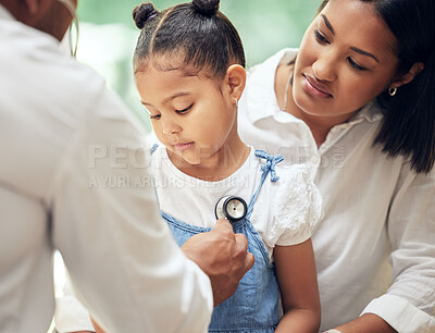Doctor examining little girl by stethoscope. Sick girl sitting with mother while male paediatrician listen to chest heartbeat. Mom holding daughter during doctor visit