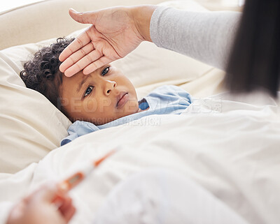Buy stock photo Sick little boy lying in bed while mother takes his temperature with thermometer and feeling forehead. Mother taking care of child with fever